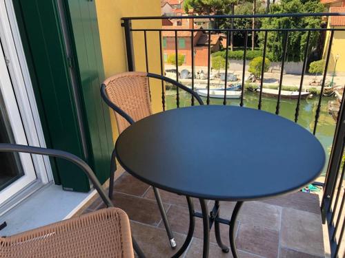 格拉多VILLA CARLOTTA GRADO的阳台上配有蓝色的桌椅
