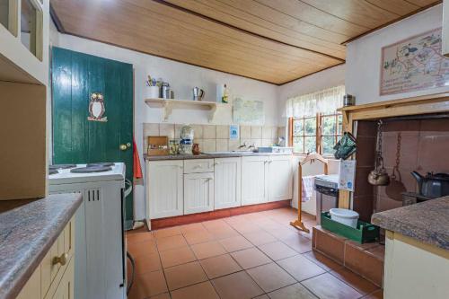 豪格斯拜克Back o' the Moon Holiday cottage的厨房配有白色橱柜和瓷砖地板。