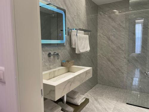 Belsh-QendraHOTEL UJVARA的一间带水槽、镜子和淋浴的浴室