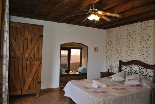圭马尔Casa Rural Aca y Papá Juan的一间卧室配有一张带吊扇的床和一扇门。