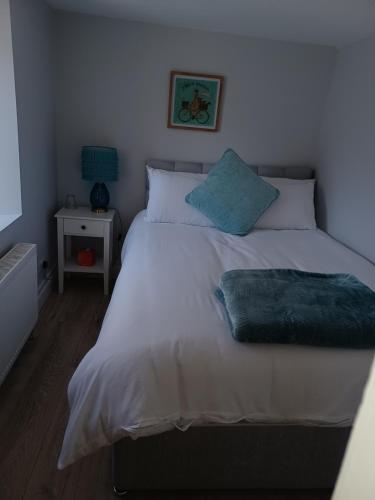 KilmacthomasKents guesthouse accommodation的一间卧室配有带白色床单和蓝色枕头的床。