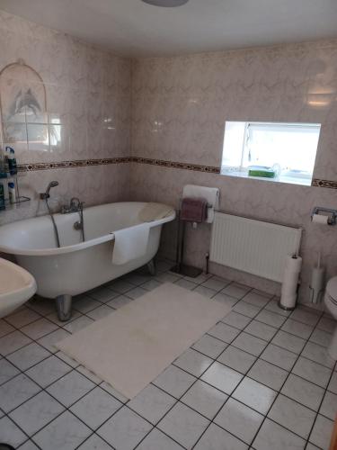 KilmacthomasKents guesthouse accommodation的白色的浴室设有浴缸和水槽。