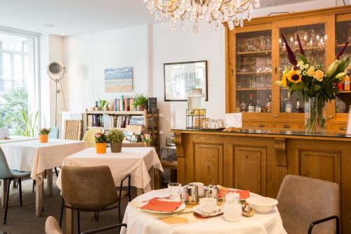 奥斯坦德德霍克美思酒店的一间带2张桌子和椅子的餐厅和一间酒吧