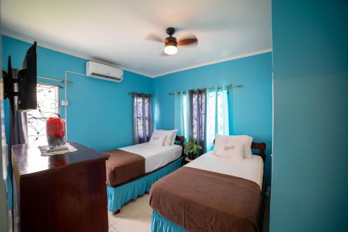 蒙特哥贝Nickels Garden Villas的蓝色客房 - 带两张床和梳妆台