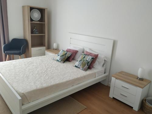 坎普自由鎮Brava的卧室配有带枕头和蓝椅的白色床