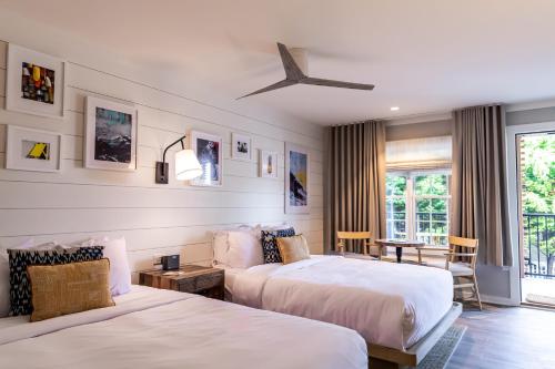 五月岬郡Boarding House Cape May的酒店客房设有两张床和窗户。
