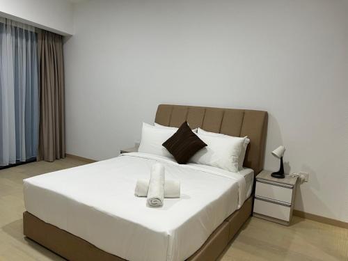 吉隆坡Eaton Suites KLCC的卧室配有一张白色大床和两条毛巾