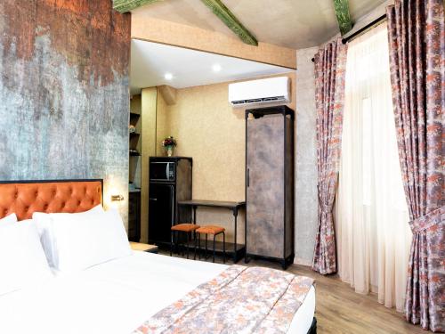 第比利斯6 Unique Apartments的配有一张床和一张书桌的酒店客房