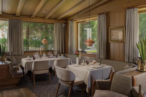 塞尔瓦迪加尔代纳山谷甘智亚娜酒店的用餐室设有桌椅和窗户。