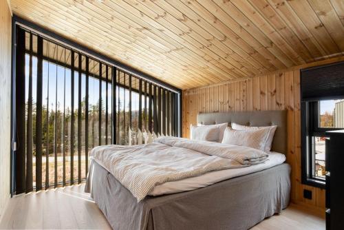 GaustablikkGaustablikk Hytte - MountainView的一间卧室设有一张大床和一个大窗户