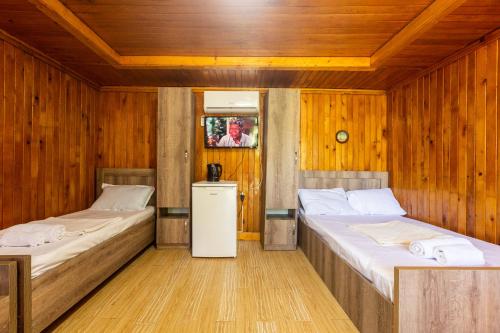 库塔伊西Eco Cottage的木墙客房的两张床