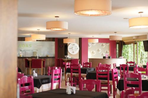 布卡拉曼加Hotel Ciudad Bonita的用餐室配有粉红色的桌椅和时钟