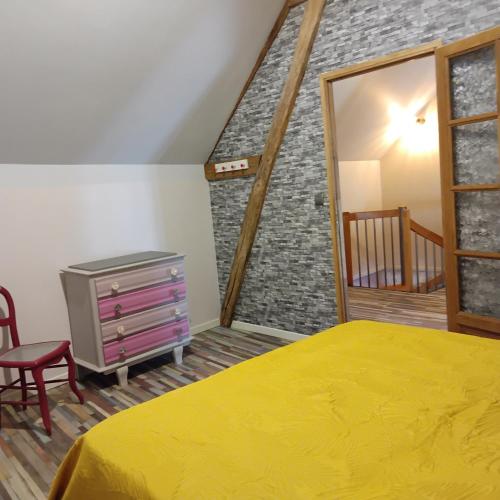 BuéLa coquette的一间卧室设有黄色的床和砖墙