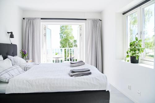 赫尔湾Lotsvillan的一间白色卧室,配有两张床和窗户