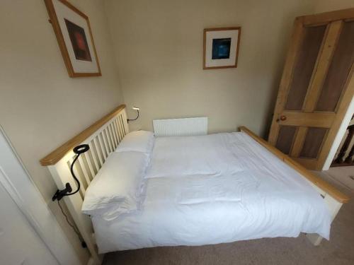 莫法特Character cottage in centre of Moffat的一间卧室配有一张白色的木架床