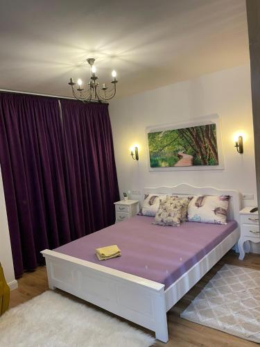巴亚马雷Apartament Gabriela 39的一间卧室配有一张带紫色床单的大床