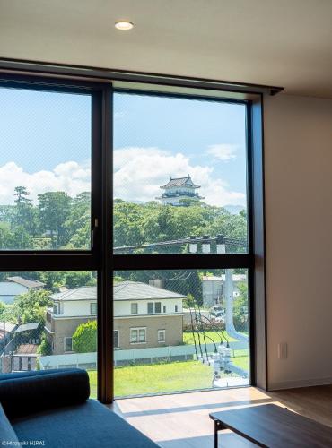 小田原市THE VIEW Odawara shiro-no mieru hotel - Vacation STAY 66090v的客房设有大窗户,享有大楼的景致。