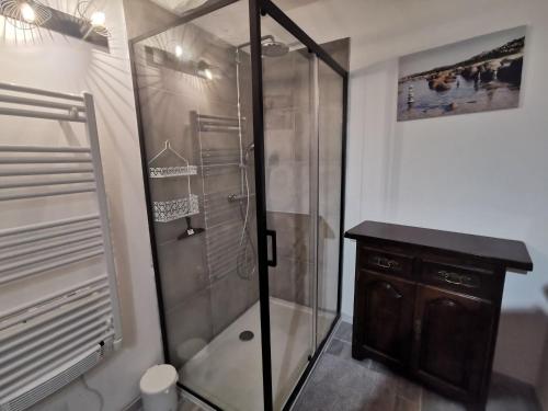 马洛塞讷La suite du beffroi的浴室设有玻璃淋浴间和木橱柜