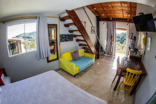南蒙蒂阿莱格里Chalé vista incrível Monte Alegre Village的客厅设有黄色沙发和楼梯。