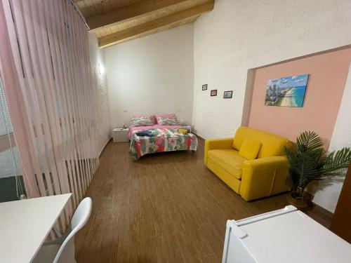 马拉泰亚Holiday Home NomiS的客厅配有黄色椅子和床
