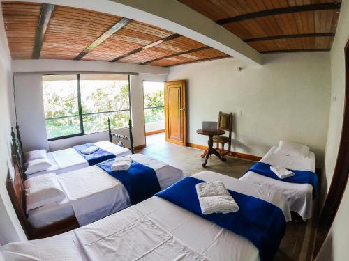 San CarlosFINCA HOTEL CURIBAY的带三张床和窗户的客房