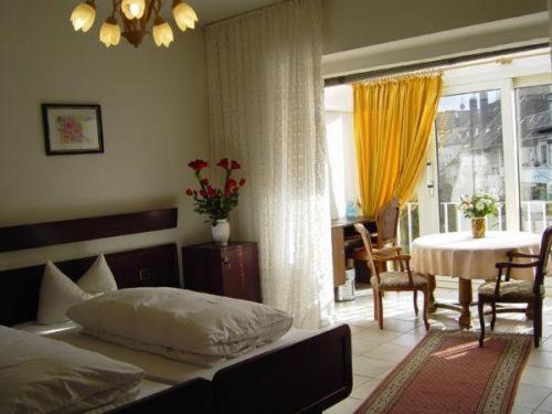 杜塞尔多夫豪斯慕瑞伽尼酒店的一间卧室配有一张床铺和一张桌子,还有一间用餐室