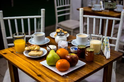 圣胡安Hotel Estrella Andina的一张木桌,早餐包括水果和果汁