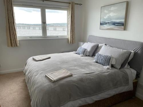 邓迪Lux Waterfront 2 bed Apt, V&A 10min walk, St Andrew's Golf 25min drive的一间卧室设有一张大床和窗户