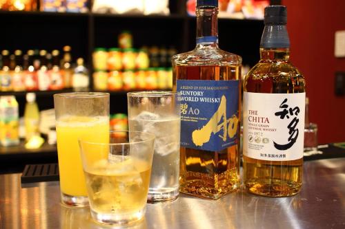 东京Henn na Hotel Tokyo Asakusa Tawaramachi的酒吧提供一瓶威士忌和两杯酒