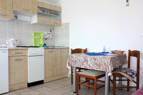 罗戈兹尼察Apartments with a parking space Rogoznica - 4865的一个带桌椅的小厨房