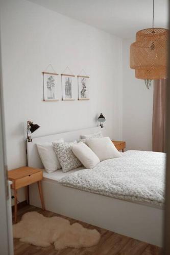 多纳瓦利Bon Repos Apartmán的一间卧室配有带白色床单和枕头的床。