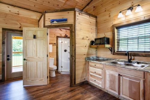 赛维尔维尔Patriots Tiny Home w Hot Tub Fire Pit Grill的小屋内的厨房设有水槽和卫生间
