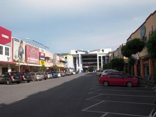 瓜埠ISLAND TIME MOTEL KUAH的一条城市街道,有汽车停在停车场