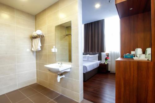 乔治市CitiVilla Penang的一间带水槽的浴室和一张位于客房内的床