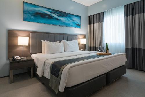 宿务Bayfront Hotel Cebu North Reclamation的一张大床,位于酒店带两盏灯的房间