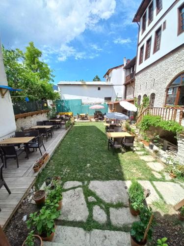 番红花城Muhsin Bey Konağı的庭院配有桌椅和草地。