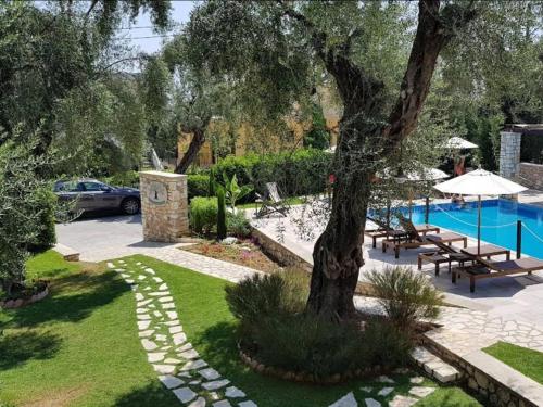 帕尔加Vassilis Guest House的一座花园,花园内种有树木,并设有一个游泳池