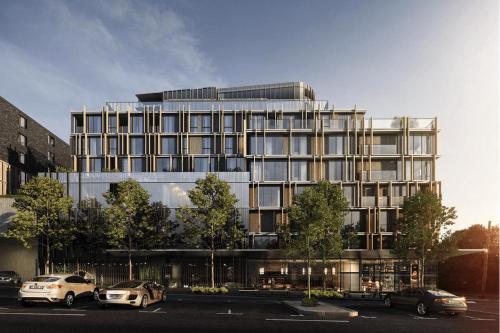 墨尔本Melbourne City Apartment Hotel的停车场内停放汽车的大型建筑