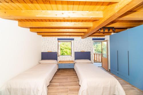 伊巴兰格鲁LAGA Surf VILLA by Urdaibai Rentals的木天花板的客房内的一排床位