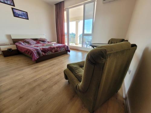 马钦加里Apartments Sunset Paradise的一间卧室配有一张床、一张沙发和一把椅子
