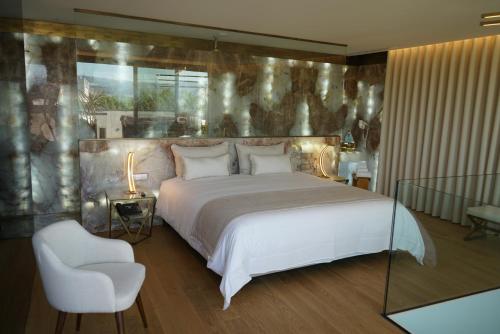 查韦斯Castelo Hotel的卧室配有一张白色大床和一把椅子