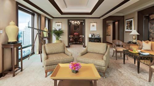 曼谷The Peninsula Bangkok的客厅配有沙发、椅子和桌子