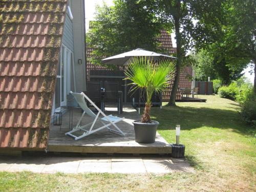 RonshausenFerienhaus Waldperle的一个带椅子、遮阳伞和植物的庭院