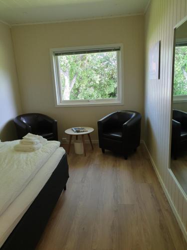 Banken Bed & Breakfast的一间卧室配有两把椅子、一张床和窗户