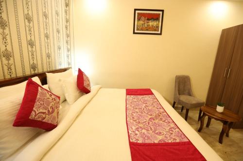 法里达巴德Hotel Lavit Couple Friendly near Faridabad Metro station的一间卧室配有一张带红色枕头的大床