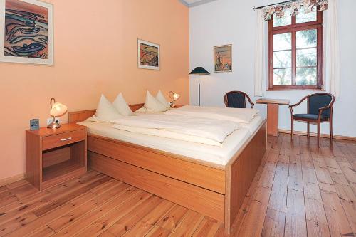 丹加斯特Pension Altes Posthaus的卧室内的一张大床,配有一张桌子和一把椅子