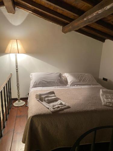 斯波莱托Borgo delle Mole的卧室内的一张床位,配有灯和床罩