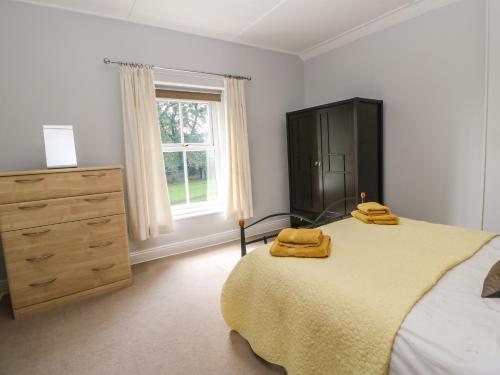 毕晓普奥克兰Church View Cottage的一间卧室配有一张带两张黄色毛巾的床