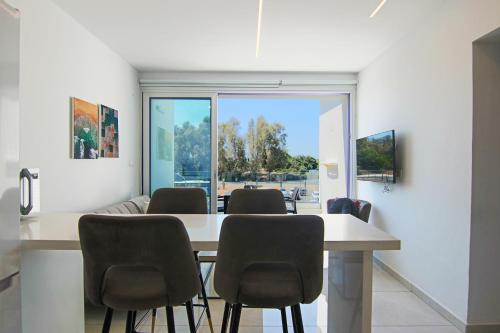 PaphosPhaedrus Living - Seaside Executive Flat Harbour 203的一间带桌椅的用餐室