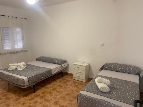 韦尔卡尔-奥韦拉Casa Retamica的一间设有两张床和床头柜的房间